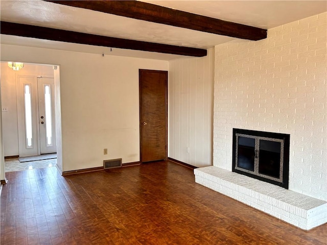 unfurnished living room with beamed ceiling, dark hardwood / wood-style flooring, and a fireplace