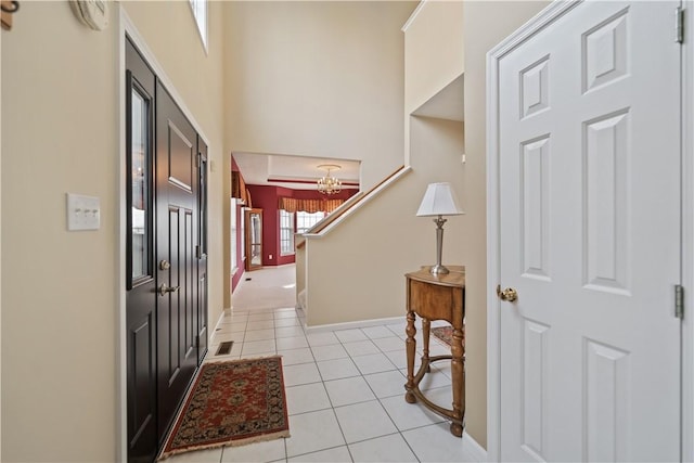 tiled entrance foyer with a chandelier