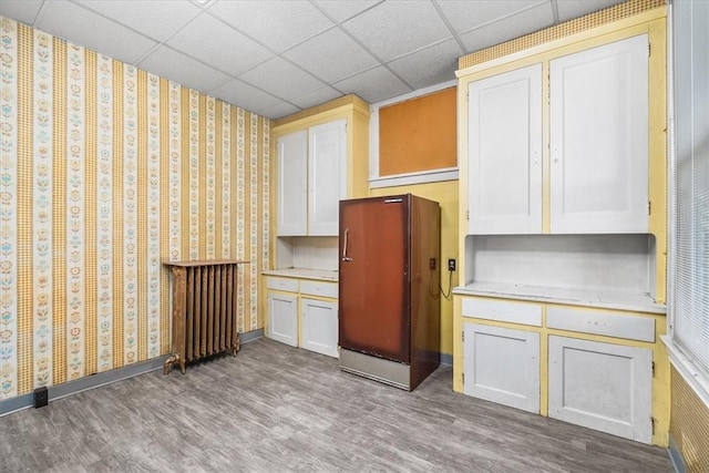 kitchen featuring a paneled ceiling, stainless steel fridge, and light hardwood / wood-style flooring