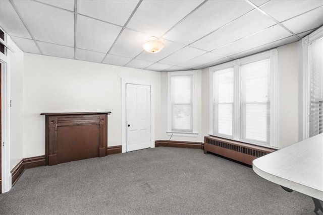 unfurnished room featuring carpet flooring, a paneled ceiling, and radiator