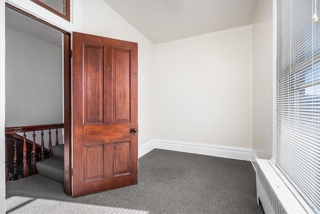 interior space with carpet flooring and vaulted ceiling