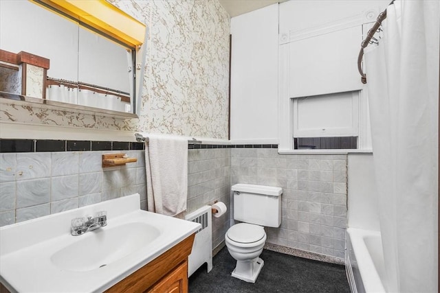 bathroom with vanity, toilet, radiator heating unit, and tile walls