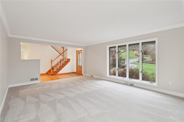 unfurnished living room featuring crown molding and light colored carpet