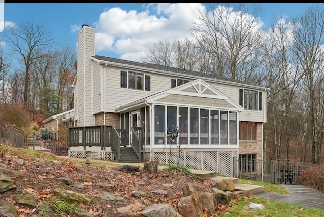 rear view of property featuring a sunroom