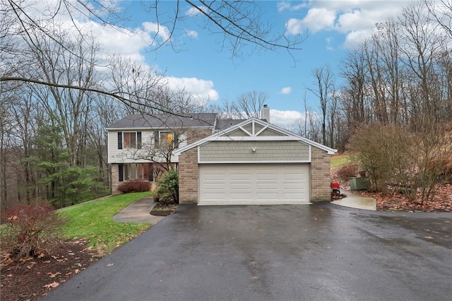 view of front of house featuring aphalt driveway, a chimney, and a garage