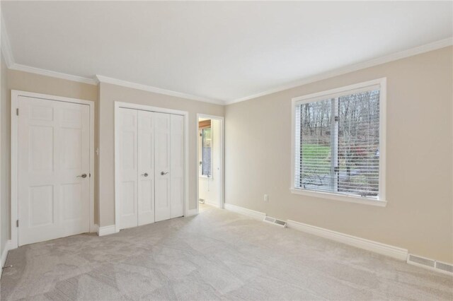 unfurnished bedroom featuring light colored carpet, a closet, and crown molding