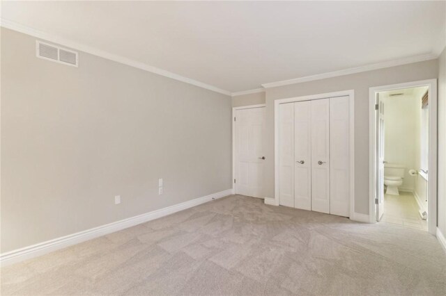 unfurnished bedroom featuring crown molding, light carpet, and ensuite bath