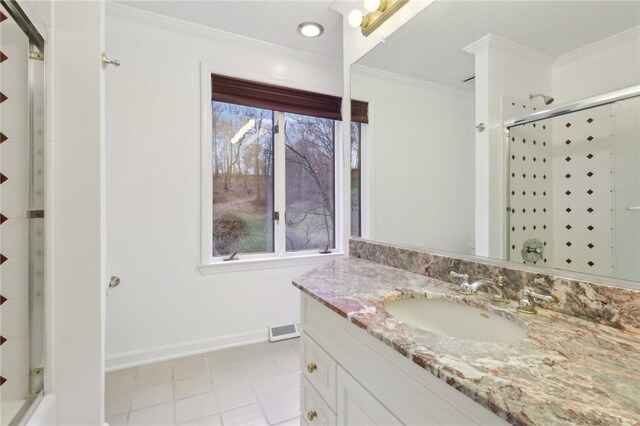 bathroom with crown molding, a healthy amount of sunlight, and a shower with shower door