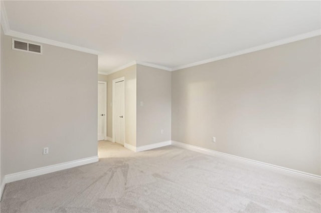 spare room featuring light carpet and crown molding