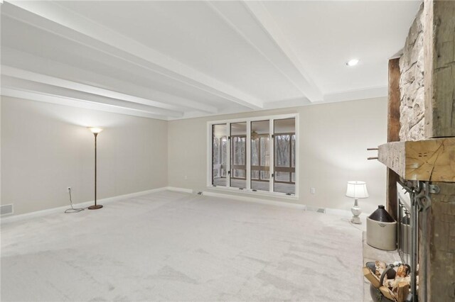 unfurnished living room with beamed ceiling and carpet floors