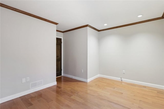 spare room with light wood-type flooring and crown molding