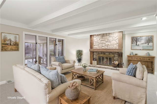 living room featuring beam ceiling, a stone fireplace, and light colored carpet