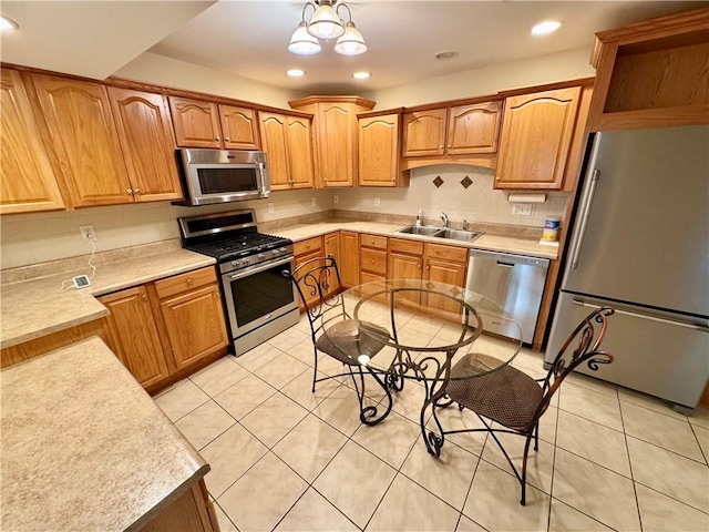 kitchen featuring sink, stainless steel appliances, a notable chandelier, decorative backsplash, and light tile patterned floors