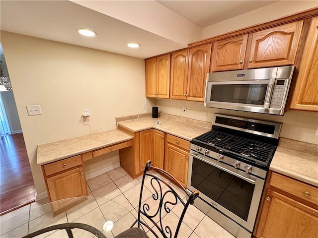 kitchen featuring appliances with stainless steel finishes, backsplash, and light tile patterned floors