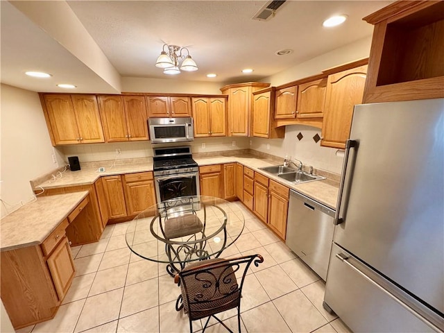 kitchen featuring light tile patterned floors, stainless steel appliances, a notable chandelier, and sink