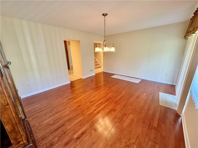 unfurnished dining area with wood-type flooring and a chandelier