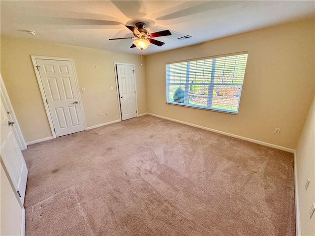 unfurnished bedroom featuring light colored carpet and ceiling fan