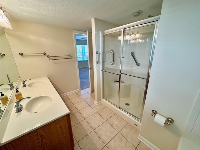 bathroom featuring tile patterned floors, vanity, a textured ceiling, and walk in shower