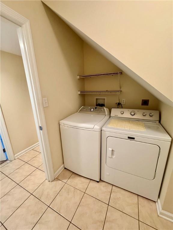 laundry room featuring light tile patterned flooring and washing machine and clothes dryer