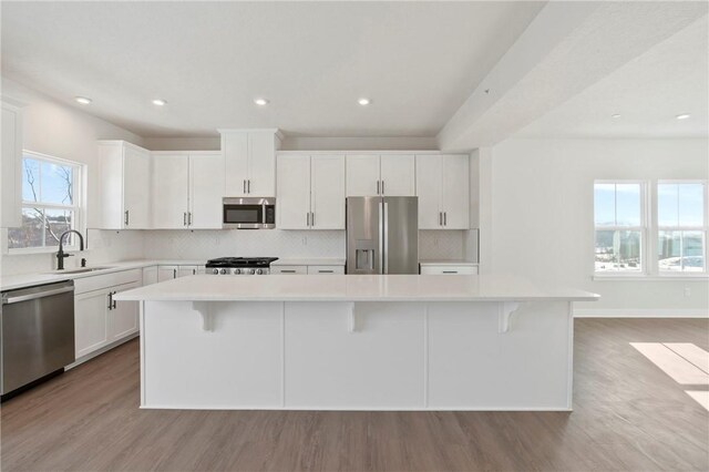 kitchen with a kitchen breakfast bar, stainless steel appliances, and a center island