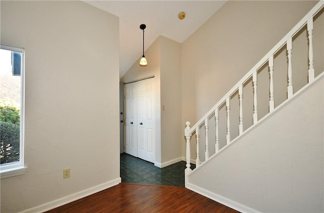 entryway with dark wood-type flooring and high vaulted ceiling