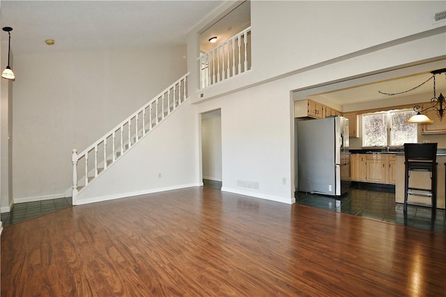 unfurnished living room featuring dark hardwood / wood-style floors and high vaulted ceiling