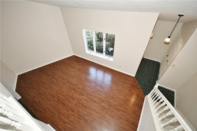 unfurnished living room featuring dark hardwood / wood-style floors and lofted ceiling