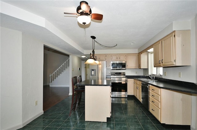 kitchen featuring sink, stainless steel appliances, dark tile patterned floors, a kitchen bar, and a kitchen island