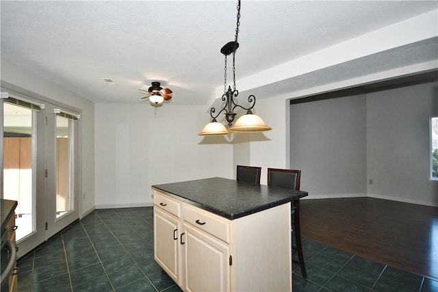 kitchen with a kitchen breakfast bar, a wealth of natural light, dark hardwood / wood-style flooring, and a center island