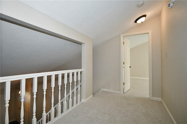 corridor featuring carpet flooring and lofted ceiling