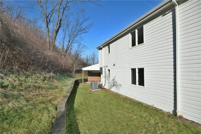 view of property exterior with cooling unit and a yard