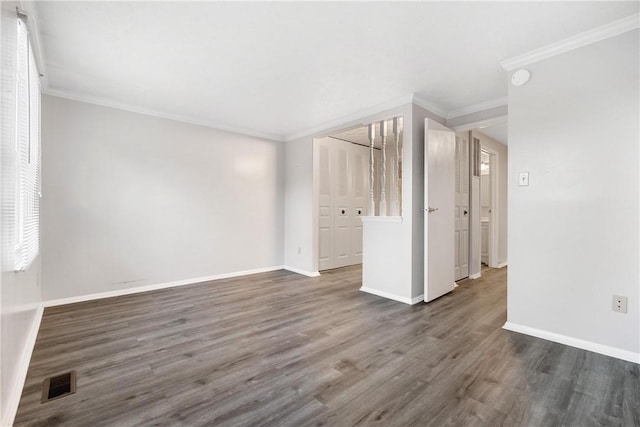 empty room with crown molding and dark hardwood / wood-style floors