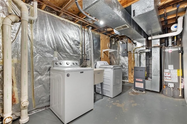 basement with washing machine and clothes dryer, electric panel, heating unit, and gas water heater