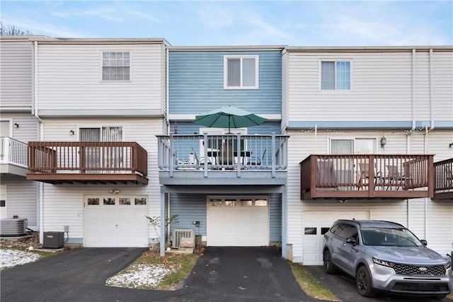 rear view of house with a garage and cooling unit