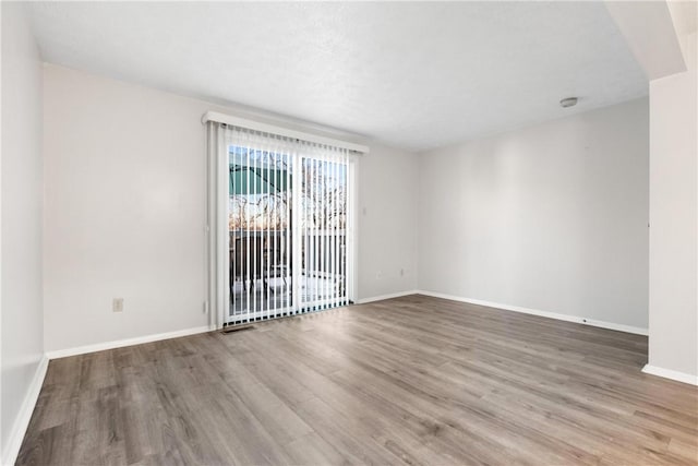 unfurnished room with wood-type flooring