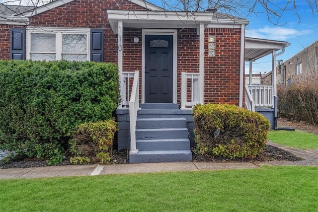 entrance to property with a lawn