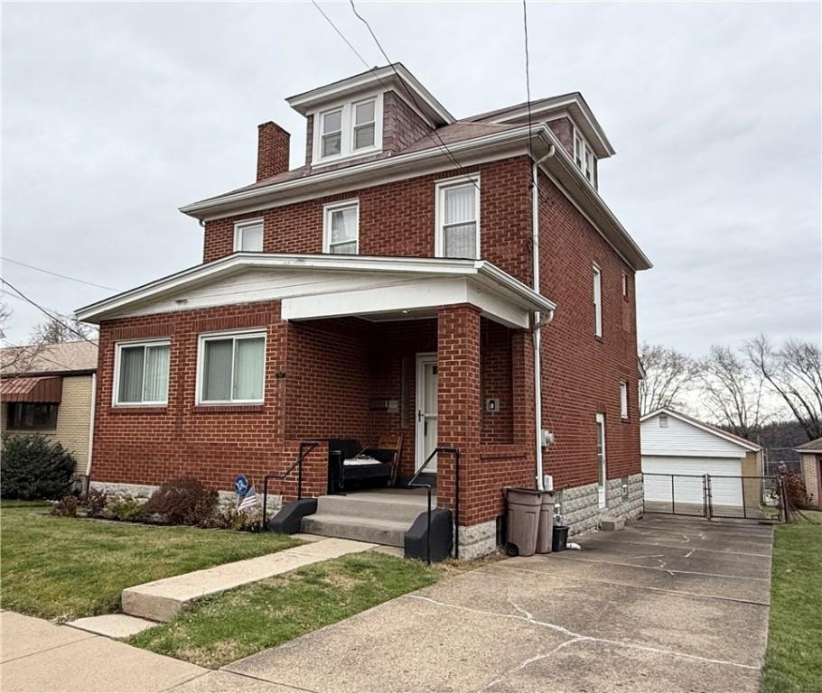 view of front of home featuring a garage, an outbuilding, and a front yard