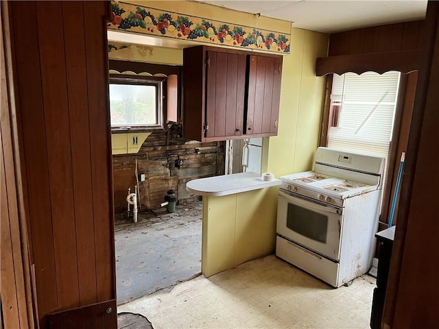 kitchen featuring kitchen peninsula and white range