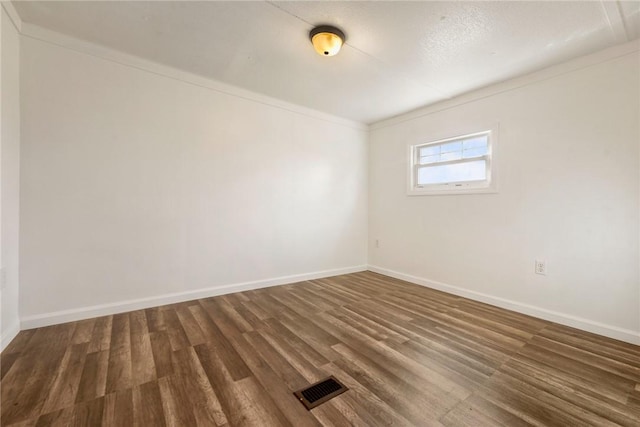 unfurnished room featuring dark hardwood / wood-style floors and ornamental molding