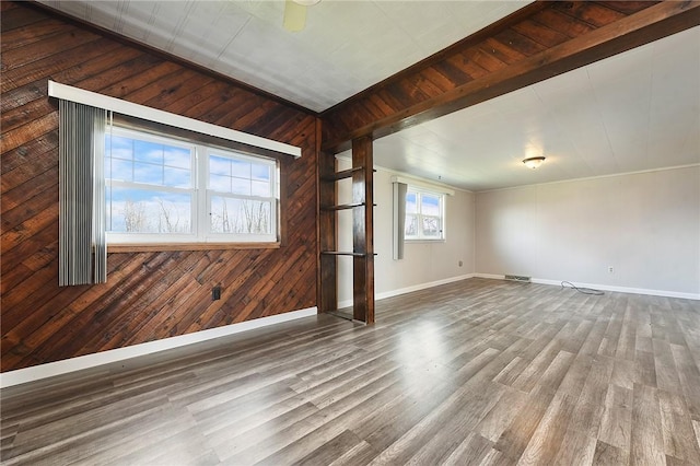 interior space with beamed ceiling, hardwood / wood-style floors, and wooden walls