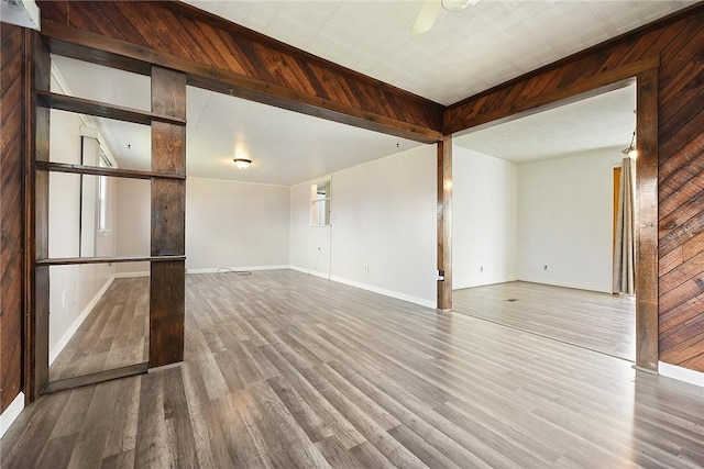 spare room with hardwood / wood-style flooring and wooden walls