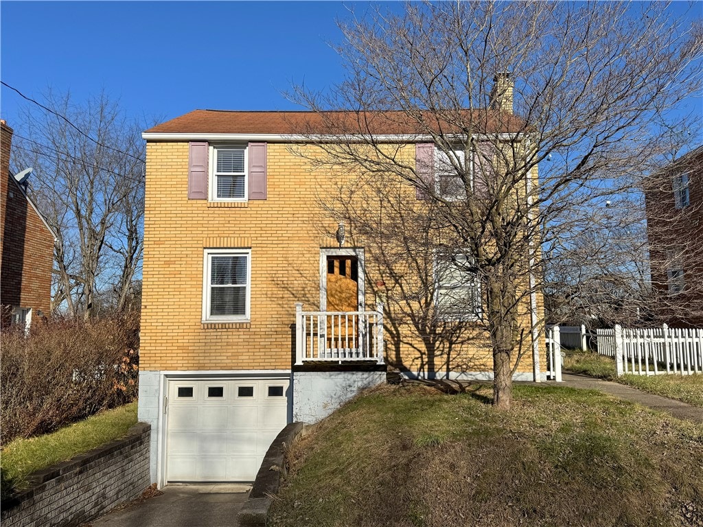 front facade with a garage and a front lawn