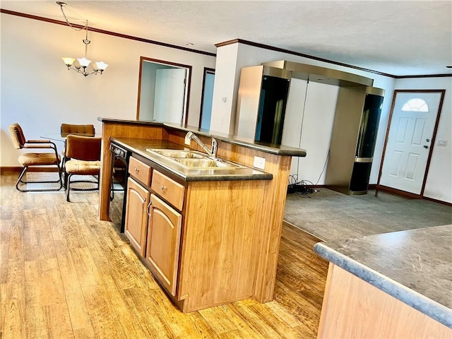 kitchen featuring light wood-type flooring, ornamental molding, sink, pendant lighting, and a notable chandelier