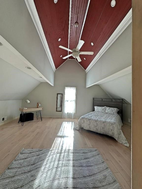 bedroom with light hardwood / wood-style floors, vaulted ceiling, ceiling fan, and ornamental molding