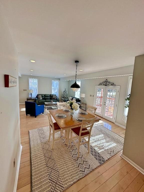 dining room with french doors, light wood-type flooring, and plenty of natural light