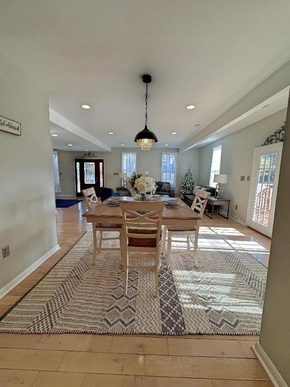 recreation room featuring a notable chandelier and light wood-type flooring