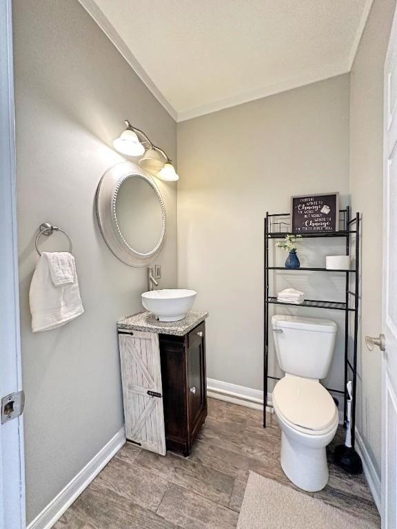 bathroom with hardwood / wood-style floors, vanity, and toilet