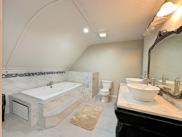 bathroom featuring tile patterned flooring, a relaxing tiled tub, vaulted ceiling, toilet, and vanity