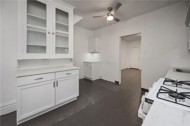 kitchen with ceiling fan, dark hardwood / wood-style flooring, white cabinetry, and white gas range oven