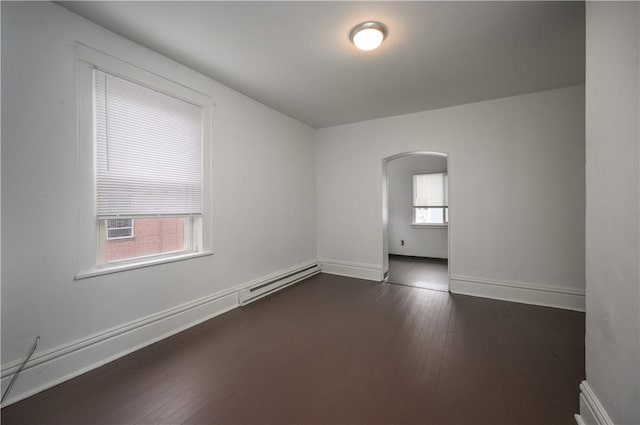 unfurnished room with dark hardwood / wood-style flooring, plenty of natural light, and a baseboard heating unit